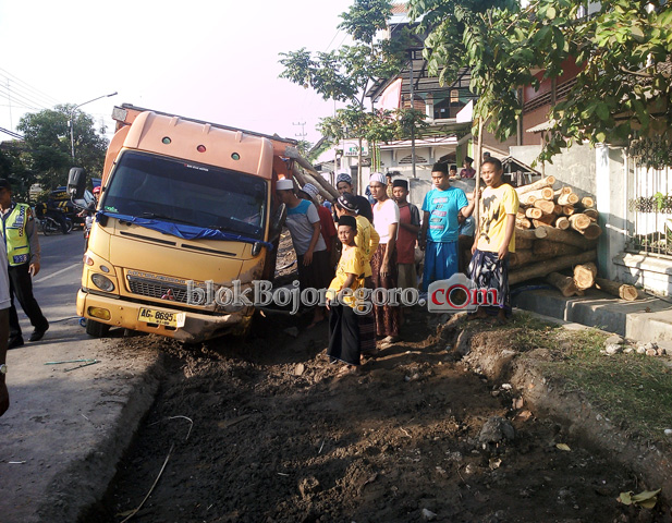 Truk Muatan Kayu Terperosok di Galian Parit di Dander